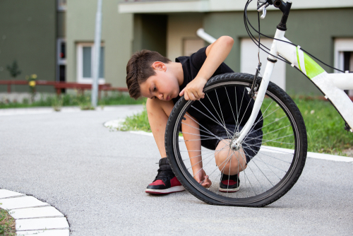 Sad,Boy,Looking,At,His,Flat,Bike,Tire,,Kid,Staring