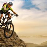 Cyclist,Riding,The,Bike,Down,The,Rock,At,Sunrise,In