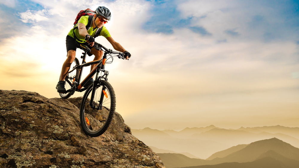 Cyclist,Riding,The,Bike,Down,The,Rock,At,Sunrise,In