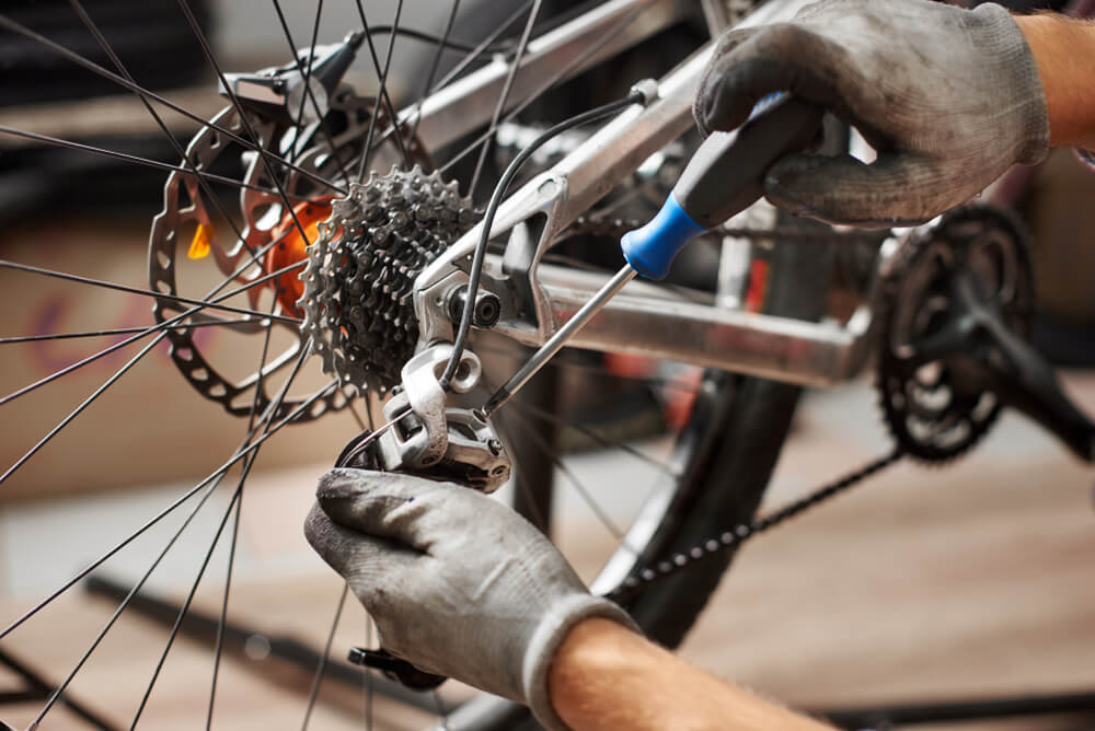 Cropped shot of male mechanic working in bicycle repair shop