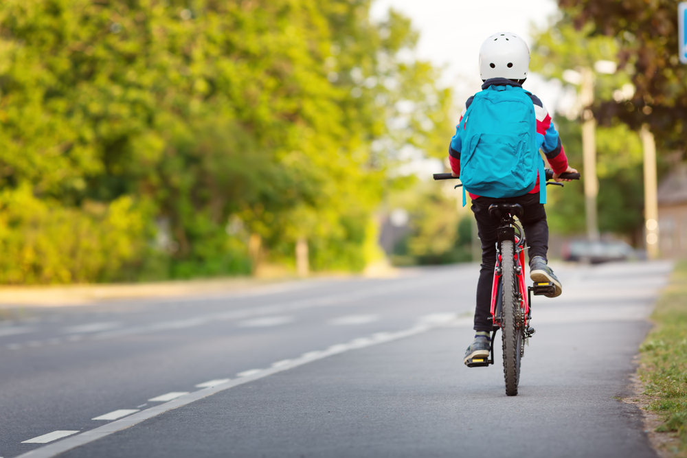 Child,With,Rucksack,Riding,On,Bikes,In,The,Park,Near